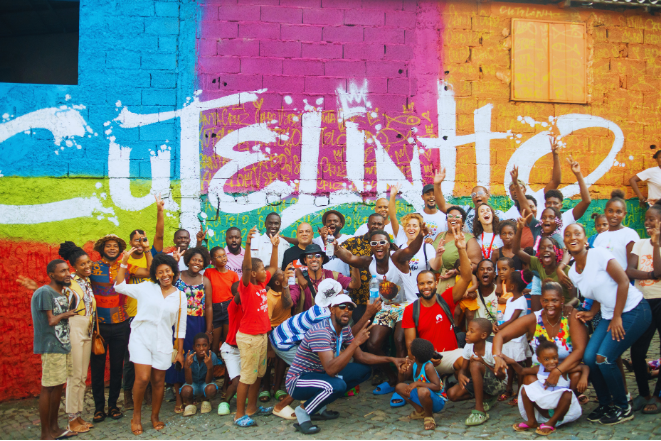Grupo de participantes em frente a um mural na Santa Cruz Art Week